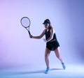 Young female tennis player preparing to hit the ball.