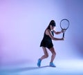 Young female tennis player preparing to hit the ball.