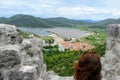 A young female tourist admiring the views of the historic medieval town of Ston, Croatia. Her view is from high up along the Wall