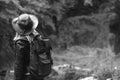 Young female tourist with backpack and cowboy hat looking at the river washed away the bridge, the crossing was impossible. Deep