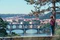 Young female tourist in a cowboy hat with sunglasses and a backpack, enjoying great view on the old town of Prague. Praha, Travel