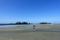 A young female tourist enjoying her view of the coast and ocean walking along Chesterman Beach outside of Tofino, British Columbia