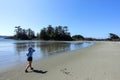 A young female tourist enjoying her view of the coast and ocean walking along Chesterman Beach outside of Tofino, British Columbia
