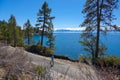 Young female tourist enjoying the sunny day by running along the beautiful lake. Royalty Free Stock Photo