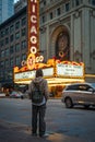 Young female tourist in front of the famous Chicago theater at night