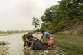 A young female tourist having fun with an elephant bathing at river with his keeper or trainer Royalty Free Stock Photo