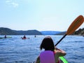 A young female tourist in a kayak exploring the beautiful waters in Bonne Bay with a group of kakayers, in Gros Morne