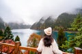 Young female tourist looking at beautiful autumn scenery landscape at jiuzhaigou national park Royalty Free Stock Photo