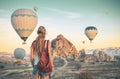 Young female tourist with colorful hot air balloon flying over Cappadocia landscape Royalty Free Stock Photo