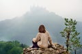 Young female tourist looking on famous Hohenzollern Castle in thick fog, Germany