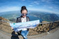 Young female tourist looking map at Rigi mountain in Switzerland with a magnificent panoramic view of Swiss alps Royalty Free Stock Photo