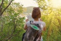 Young female tourist with map in hand wanders through the forest. Back view. Light