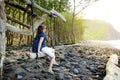 Young female tourist relaxing on a handmade swing on rocky beach of Pololu Valley on Big Island of Hawaii Royalty Free Stock Photo