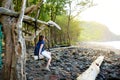 Young female tourist relaxing on a handmade swing on rocky beach of Pololu Valley on Big Island of Hawaii Royalty Free Stock Photo