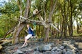 Young female tourist relaxing on a handmade swing on rocky beach of Pololu Valley on Big Island of Hawaii Royalty Free Stock Photo