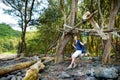 Young female tourist relaxing on a handmade swing on rocky beach of Pololu Valley on Big Island of Hawaii Royalty Free Stock Photo