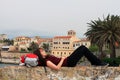 Young female tourist relaxing on her backpack, Alghero, Sardinia, Italy