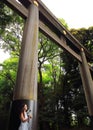 A young female tourist resting under the big torii placed in one of the entrances of Meiji-Jingu temple in Tokyo Royalty Free Stock Photo