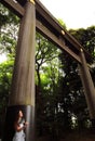 A young female tourist resting under the big torii placed in one of the entrances of Meiji-Jingu temple in Tokyo Royalty Free Stock Photo