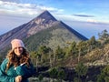 A young female tourist smiling beside her campground on the volcano Mount Acatenango.