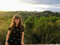 A young female tourist standing in front of a beautiful sunrise view of the Tikal Ruins and Temple IV in Tikal National Park Royalty Free Stock Photo