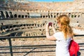 Young female tourist takes a picture inside the Coliseum in Rome Royalty Free Stock Photo