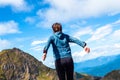 A young female tourist on top of a mountain jumps into the sky. Happiness and a sense of freedom,