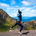 A young female tourist on top of a mountain jumps into the sky. Happiness and a sense of freedom,