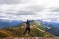 A young female tourist on top of a mountain jumps into the sky. Happiness and a sense of freedom,