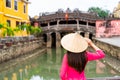 Young female in Vietnamese traditional dress walking at Hoi An Ancient town in Vietnam Royalty Free Stock Photo