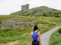A young female tourist walking up signal hill towards cabot tower. A famous landmark in St. Johns, Newfoundland, Canada