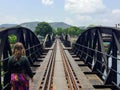 A young female tourists walks along the Bridge of the River Kwai in Kanchanaburi, Thailand/ Hot and humid but very pretty. Royalty Free Stock Photo