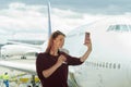 young female traveler, Blogger in airport lounge near windows happy smile taking selfie photo flight Royalty Free Stock Photo