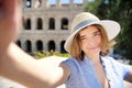 Young female traveler making selfie photo standing the Colosseum in Rome, Italy Royalty Free Stock Photo