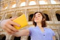 Young female traveler making selfie photo standing the Colosseum in Rome, Italy Royalty Free Stock Photo