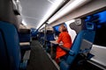 Young female traveler sitting in the modern train wagon near window Royalty Free Stock Photo