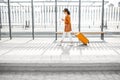 Young female traveler with a suitcase at the transport stop Royalty Free Stock Photo