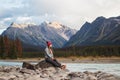 Young female traveller poses on the river stones with a breathtaking background behind, Travel Alberta, Canada, Canadian Rockies