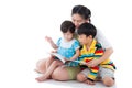 Young female with two little asian children reading a book Royalty Free Stock Photo