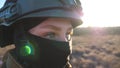 Young female ukrainian soldier in military uniform and helmet looks around her. Woman watching at camera with hope in