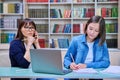 Female university student with teacher preparing for exam, inside library Royalty Free Stock Photo