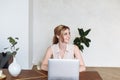 Young female using laptop, communicates on internet with customer in home on table. Cozy office workplace, remote work, E learning Royalty Free Stock Photo