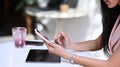 Young female using mobile phone and digital tablet while sitting at cafe. Royalty Free Stock Photo
