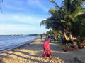 A young female vacationer goes for a peaceful stroll along the sandy beaches of beautiful Placencia, Belize