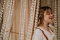 Young female in victorian shirt sitting in giant crystal chandelier and smile