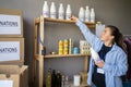 Young female volunteer packing food and drinks donation into box, people working in charitable foundation. charity Royalty Free Stock Photo