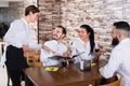 Young female waitress taking order from visitors Royalty Free Stock Photo