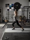 Young female weight lifter struggles with putting a heavy barbell over her head Royalty Free Stock Photo