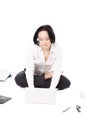 Young female worker using laptop in lotus pose on white background