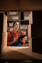 Young female worker wearing headset in logistics distribution warehouse using digital tablet over boxes background Royalty Free Stock Photo